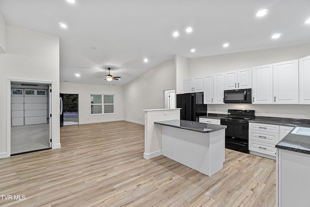 kitchen featuring ceiling fan, a kitchen island, lofted ceiling, white cabinets, and black appliances