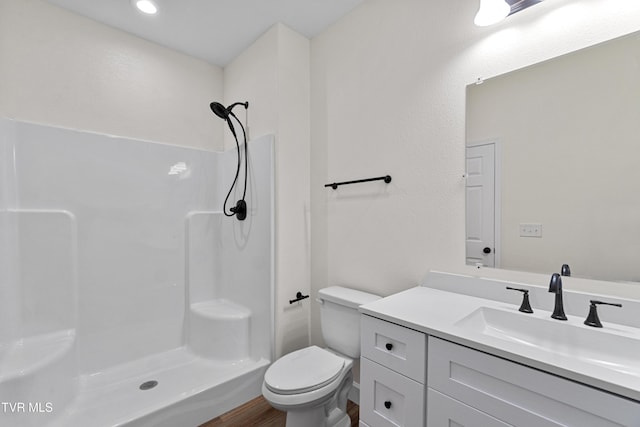 bathroom featuring wood-type flooring, vanity, toilet, and walk in shower