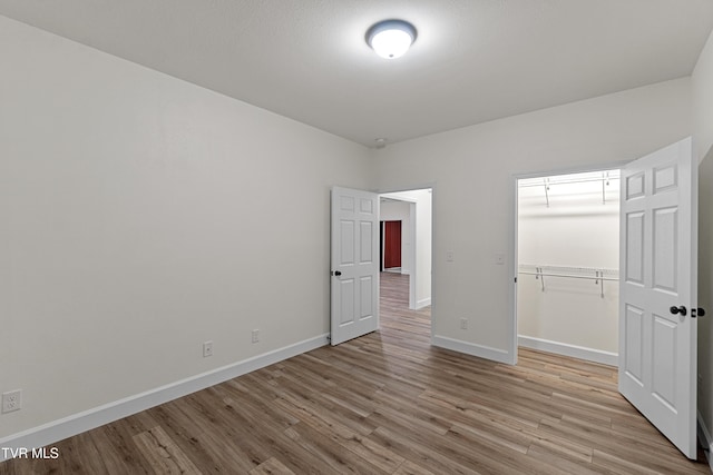 unfurnished bedroom with light wood-type flooring and a closet