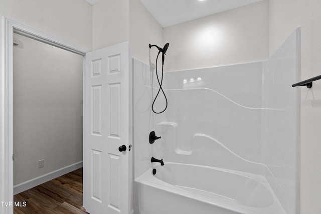 bathroom with washtub / shower combination and wood-type flooring