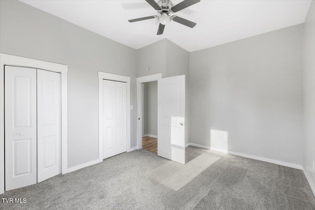 unfurnished bedroom featuring light carpet, ceiling fan, and two closets