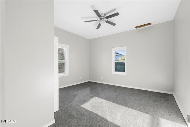 unfurnished room featuring dark colored carpet and ceiling fan