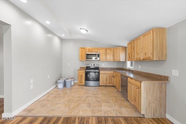 kitchen featuring light brown cabinetry, sink, vaulted ceiling, and appliances with stainless steel finishes