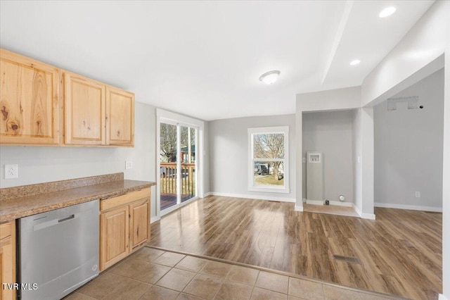 kitchen featuring light brown cabinets, light tile patterned floors, and stainless steel dishwasher