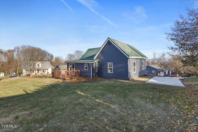 rear view of property featuring a yard and a wooden deck