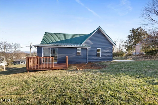 rear view of property featuring a deck and a lawn