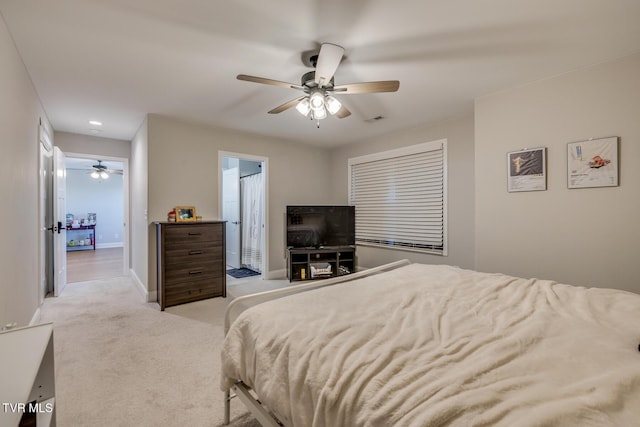 bedroom with connected bathroom, ceiling fan, and light colored carpet