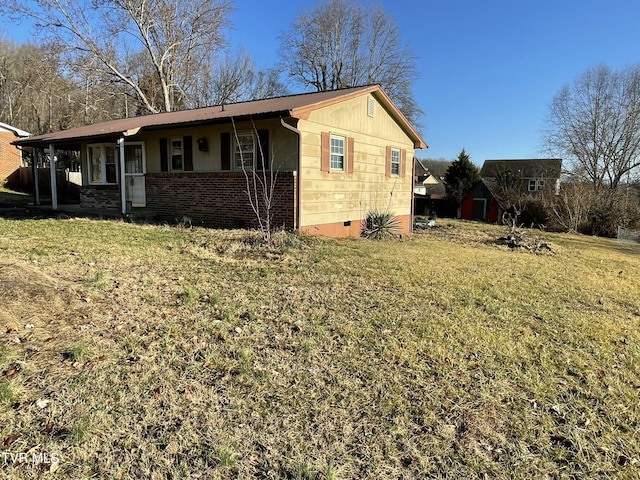 view of side of home with a yard