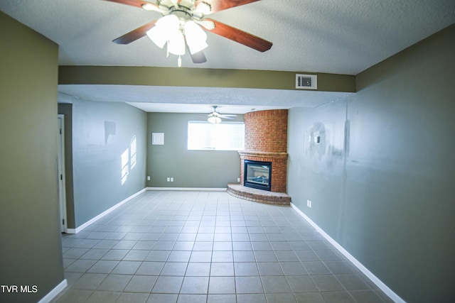 unfurnished living room with tile patterned floors, a fireplace, ceiling fan, and a textured ceiling