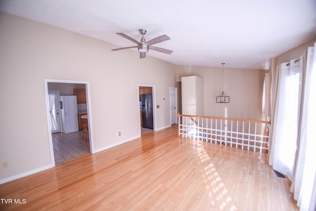 spare room featuring light wood-type flooring, ceiling fan, and lofted ceiling