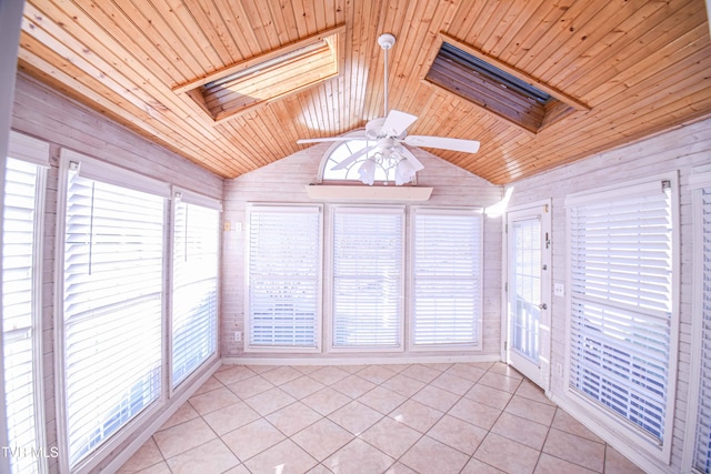 unfurnished sunroom with ceiling fan, vaulted ceiling with skylight, and wood ceiling