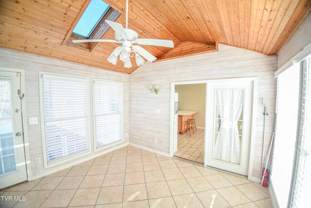 unfurnished sunroom featuring ceiling fan, a healthy amount of sunlight, wooden ceiling, and lofted ceiling with skylight