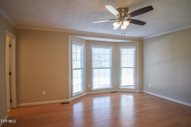 unfurnished room featuring ceiling fan, ornamental molding, a textured ceiling, and light wood-type flooring