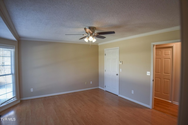 spare room featuring hardwood / wood-style floors, ornamental molding, and a wealth of natural light