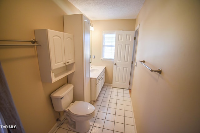 bathroom featuring tile patterned flooring, vanity, toilet, and a textured ceiling