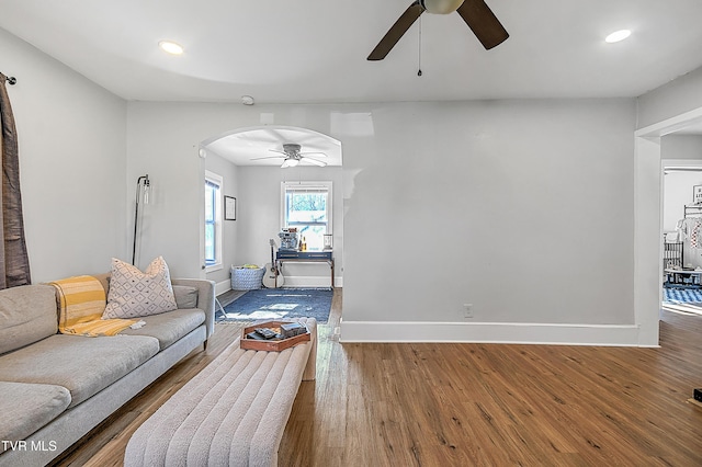 living room featuring wood-type flooring and ceiling fan