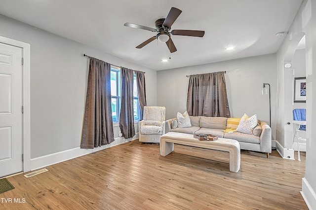 living room with ceiling fan and light hardwood / wood-style flooring