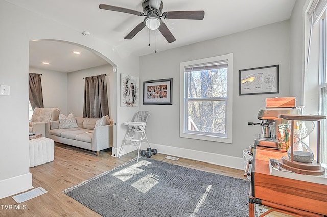 living room with ceiling fan and light wood-type flooring