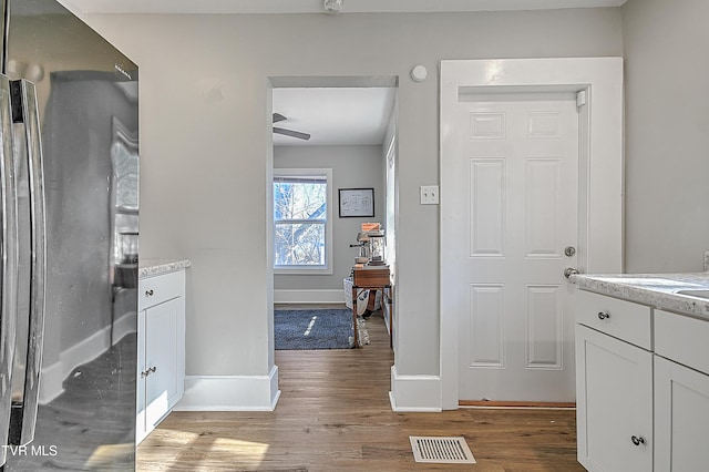 bathroom featuring wood-type flooring, vanity, and ceiling fan