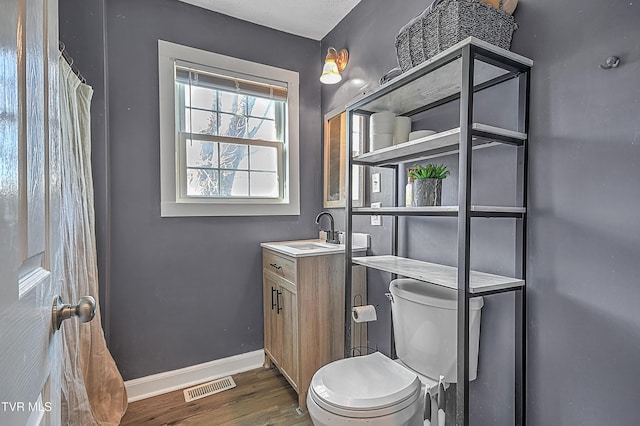 bathroom featuring vanity, wood-type flooring, and toilet