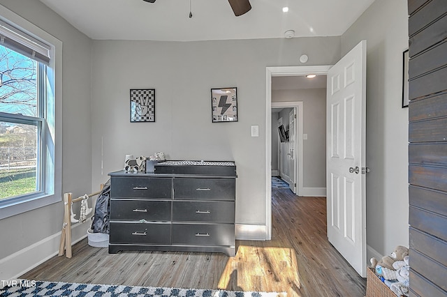 bedroom with ceiling fan, light hardwood / wood-style floors, and multiple windows