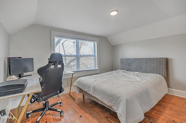 bedroom with wood-type flooring and vaulted ceiling