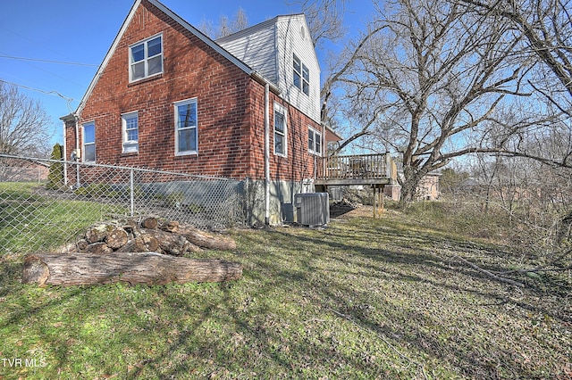 view of property exterior featuring cooling unit, a wooden deck, and a lawn