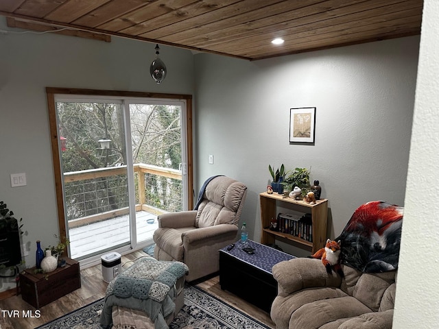 sitting room with wood-type flooring, crown molding, and wooden ceiling