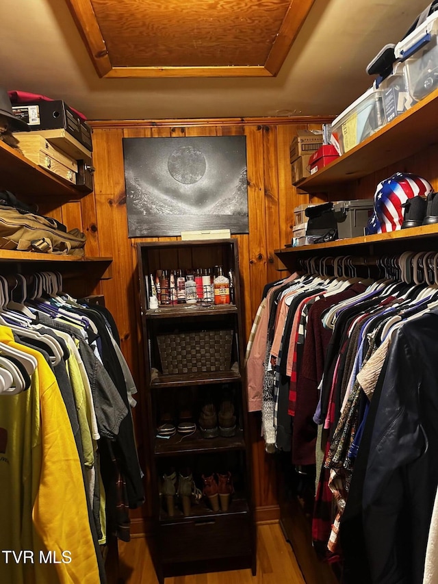 walk in closet featuring hardwood / wood-style flooring and a tray ceiling