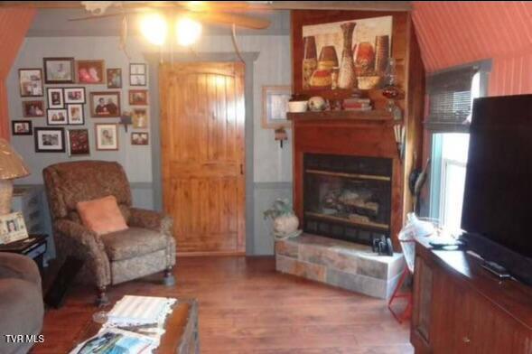 living room with a fireplace, hardwood / wood-style flooring, and ceiling fan