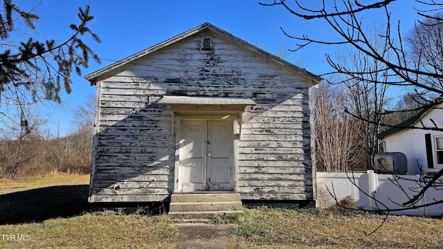 view of front of property featuring a shed