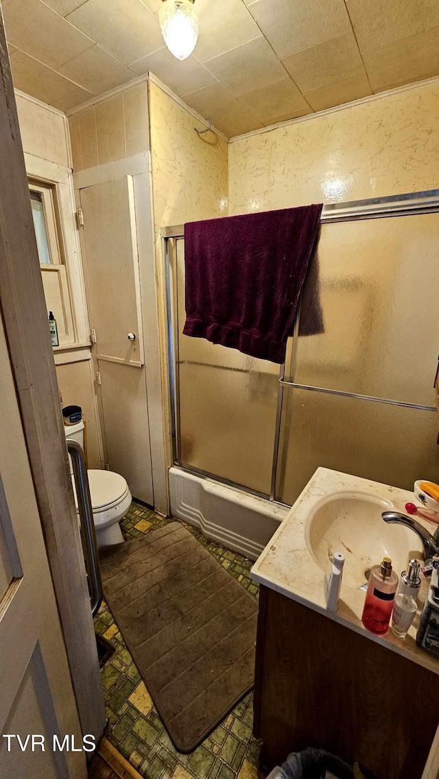 full bathroom featuring vanity, toilet, and bath / shower combo with glass door