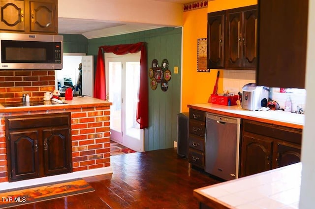 kitchen featuring backsplash, tile countertops, dark hardwood / wood-style flooring, and appliances with stainless steel finishes