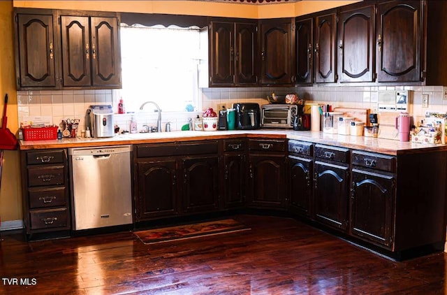 kitchen featuring tasteful backsplash, dark brown cabinetry, sink, dishwasher, and dark hardwood / wood-style floors