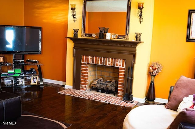 living room with wood-type flooring and a brick fireplace