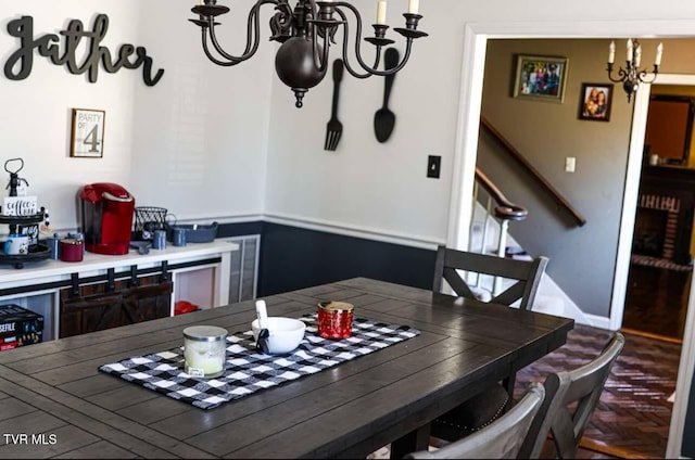 dining space featuring parquet floors and a notable chandelier