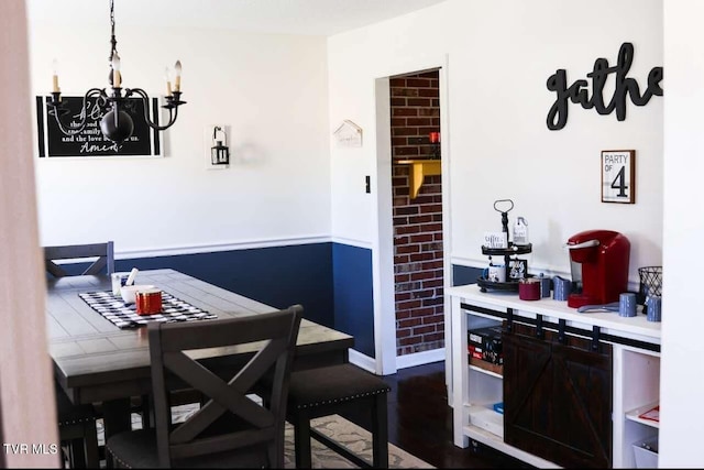 dining area with a notable chandelier and dark hardwood / wood-style flooring