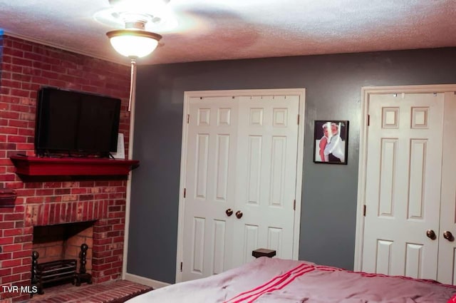 bedroom with a fireplace and a textured ceiling