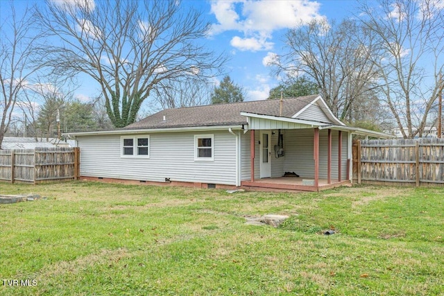 rear view of house with a deck and a yard