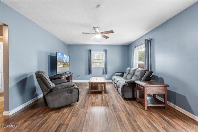 living room featuring a textured ceiling, dark hardwood / wood-style floors, and ceiling fan