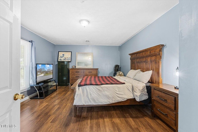 bedroom featuring dark wood-type flooring and a textured ceiling