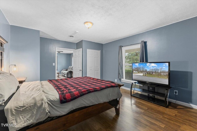 bedroom with a textured ceiling and dark hardwood / wood-style floors