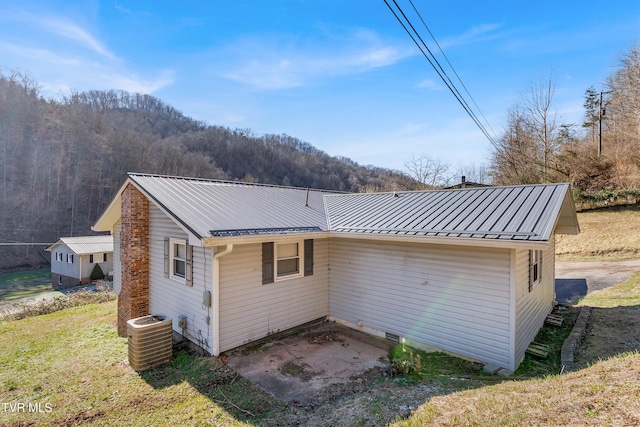 rear view of property featuring central air condition unit, a patio area, and a yard