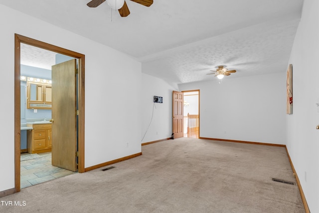 carpeted empty room with a textured ceiling and ceiling fan