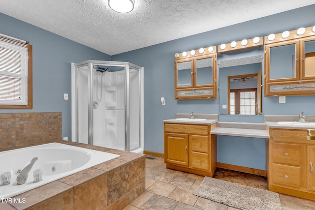 bathroom featuring separate shower and tub, vanity, and a textured ceiling