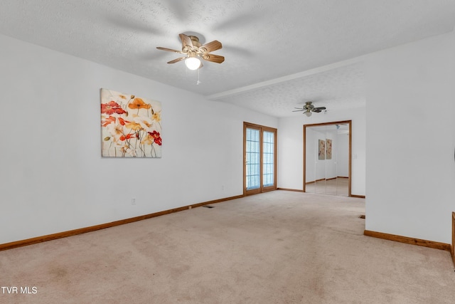 unfurnished room featuring ceiling fan, light colored carpet, and a textured ceiling