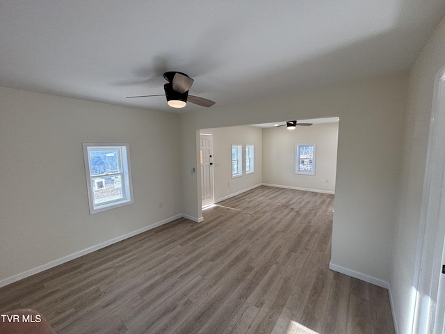 unfurnished living room with ceiling fan, a healthy amount of sunlight, and light wood-type flooring