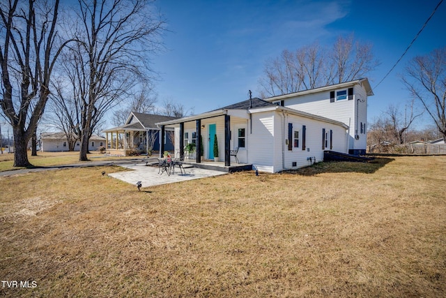 back of house with a patio and a yard