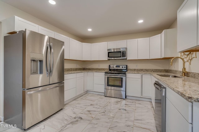 kitchen featuring appliances with stainless steel finishes, sink, and white cabinets