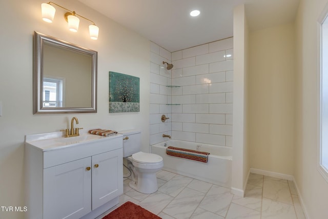 full bathroom featuring tiled shower / bath, vanity, and toilet